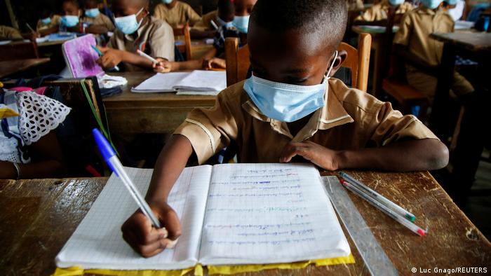 Ein Schüler der Merlan School in Abidjan, Elfenbeinküste, sitzt mit Mundschutz im Klassenzimmer.