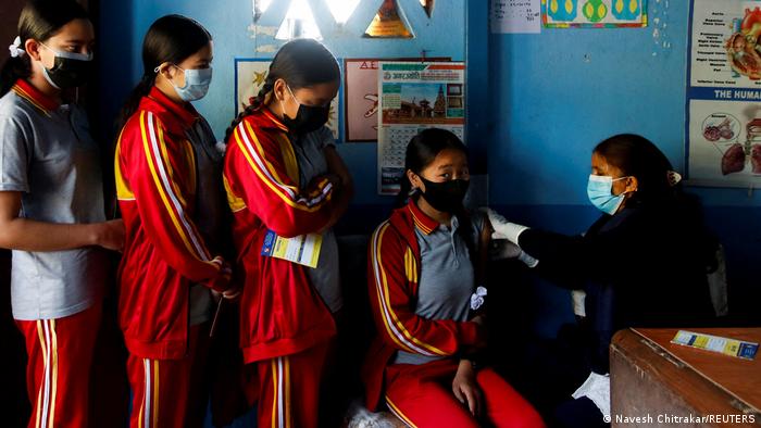 Schulmädchen stehen Schlange, um sich an ihrer Schule in Bhaktapur, Nepal, gegen das Coronavirus impfen zu lassen.