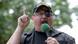 Stewart Rhodes wears a black cap with the words "Oath Keepers, Lifetime Member" embroidered on it in yellow. He wears his customarly black eyepatch and glasses and speaks into a microphone while pointing his finger. Stewart Rhodes wears a black cap with the words "Oath Keepers, Lifetime Member" embroidered on it in yellow. He wears his customarly black eyepatch and glasses and speaks into a microphone while pointing his finger.