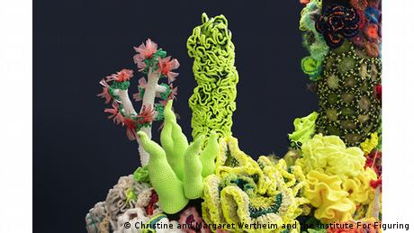 Grüne und gelbe gehäkelte Korallen vor schwarzem Hintergrund