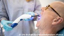 Thema: Zahnarzt. Medizintechnische Fachangestellte arbeitet mit einer UV Lampe zur Aushaertung eines Kunststoffes. || Modellfreigabe vorhanden