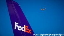 This photograph taken on August 6, 2018, shows an aircraft of Scandanavian Airline SAS (R) as it flies past a McDonnell Douglas MD11 aircraft of US parcel delivery giant FedEx on the tarmac at Roissy-Charles de Gaulle Airport, north of Paris. (Photo by JOEL SAGET / AFP) (Photo by JOEL SAGET/AFP via Getty Images)