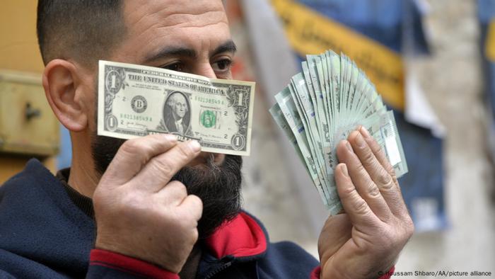 An exchange dealer shows money at a currency exchange office as the value of the Lebanese currency against the US dollar continues to drop