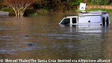 A pickup truck is partially submerged in Santa Cruz, Calif., early Saturday, Jan. 15, 2022, as the surge from a tsunami created by an underwater volcano near Tonga inundated a parking lot at the Upper Harbor. Moments later all the water receded from the lot before flooding it again shortly thereafter. (Shmuel Thaler/The Santa Cruz Sentinel via AP)