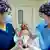 Neném recém-nascido segurado por duas enfermeiras