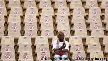 A football fan sits in empty tribunes with seats blocked-off prior to the Group C Africa Cup of Nations (CAN) 2021 football match between Morocco and Comoros at at Stade Ahmadou Ahidjo in Yaounde on January 14, 2022. (Photo by Kenzo Tribouillard / AFP) (Photo by KENZO TRIBOUILLARD/AFP via Getty Images)