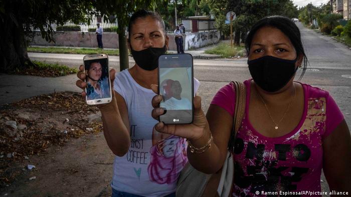 Madres de los manifestantes Eloy Bárbaro Cardoso (de 18 años ) y Dariel Cruz (de 20) muestran fotos de sus hijos, frente al juzgado donde fueron procesados, en La Habana.