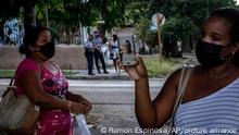 Yunisleydis Rios shows a photo of her 32-year-old brother Yerandis Rios, who was arrested during the July 11 protests, in front of the court building where he is being tried in Havana, Cuba, Tuesday, Jan. 11, 2022. Six months after surprising protests against the Cuban government, more than 50 protesters who have been charged with sedition are headed to trial and could face sentences of up to 30 years in prison. (AP Photo/Ramon Espinosa)