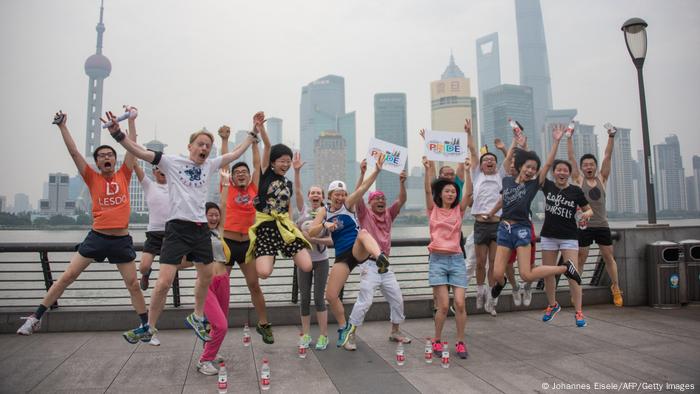 Participants of a Shanghai Pride Run jump up into the air (2015)