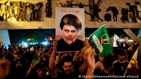 Followers of Shiite cleric Muqtada al-Sadr celebrate, holding his posters after the announcement of the results of the parliamentary elections on Tahrir Square, Baghdad, Iraq
