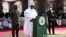 Nigerian President Muhammadu Buhari (C) delivers a speech at the launch of the largest rice pyramids in Abuja, Nigeria, on January 18, 2022. - The bags of rice which were planted and harvested by Rice Farmers Association of Nigeria (RIFAN) from states in Nigeria, are one million rice paddies stacked in 15 separate pyramids which is expected to solve the food crisis in Nigeria. (Photo by Koula Sulaimon / AFP)