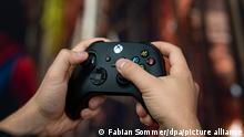 A person holds an XBox controller 