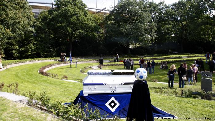 Pemakaman penggemar HSV: Orang-orang di halaman besar, HSV biru, hitam dan putih menonjol