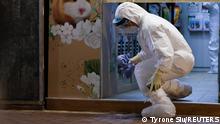 A wildlife officer with personal protective equipment leaves a temporarily closed pet shop, after the government announced to euthanize around 2,000 hamsters in the city after finding evidence for the first time of possible animal-to-human transmission of coronavirus disease (COVID-19), in Hong Kong, China, January 18, 2022. REUTERS/Tyrone Siu