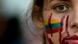 A young Colombian woman with the national colors (yellow, blue and red) painted on her cheeck, as well as smears of red paint mimicking blood. A young Colombian woman with the national colors (yellow, blue and red) painted on her cheeck, as well as smears of red paint mimicking blood.