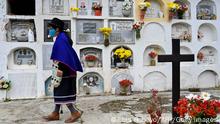 A Misak indigenous woman visits the cemetery to fix the graves of her deceased relatives during the celebration of the offering ceremony in Silvia, Cauca department, Colombia, on November 1, 2020. - The offering ceremony -during which the deceased relatives come to visit and they are offered altars with food- is celebrated every year starting on October 31, which marks the end of the year for the Misak people. According to their belief, when people die they go to the 'cansre', which is neither heaven nor hell of the Christian belief. (Photo by Luis ROBAYO / AFP) (Photo by LUIS ROBAYO/AFP via Getty Images)