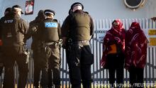 Migrants stand with police on the beach after crossing the English Channel in an inflatable dinghy, in Dungeness, Britain, January 18, 2022. REUTERS/Henry Nicholls 