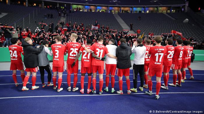 Union Berlin's players celebrate victory against Hertha with the pocket of 200 Union fans.