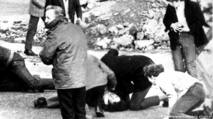 People attend to an injured person during Bloody Sunday masscare