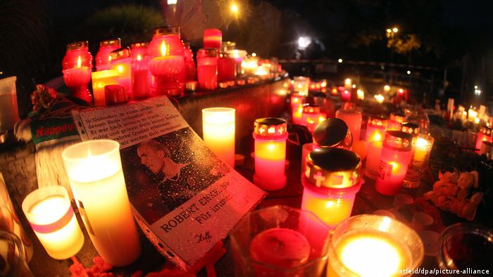 Photo of Robert Enke, surrounded by lit candles at night 