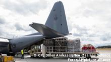 In this photo provided by the New Zealand Defence Force, a Royal New Zealand Air Force C-130 Hercules is loaded before it leaves an airbase in Auckland, Thursday, Jan. 20, 2022, flying to Tonga with aid. The first flight carrying fresh water and other aid to Tonga was finally able to leave Thursday after the Pacific nation's main airport runway was cleared of ash left by a huge volcanic eruption. (CPL Dillon Anderson/New Zealand Defence Force via AP)