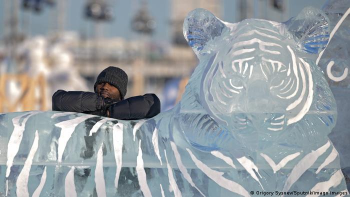 Un hombre posa junto a la escultura de hielo de un tigre en el Parque Gorky de Moscú.