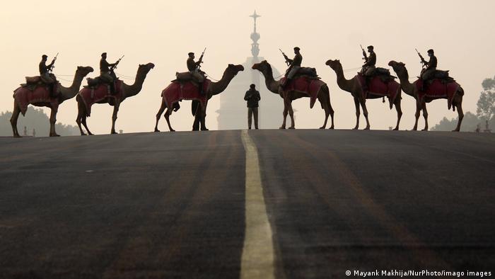 Sechs Kamele mit Soldaten stehen sich gegenüber