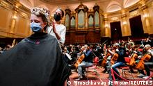 A customer gets a haircut in a concert hall as museums and concert halls protest against government rules allowing gyms and hairdressers to re-open while they have to stay shut due to coronavirus disease (COVID-19) restrictions in Amsterdam, Netherlands January 19, 2022. REUTERS/Piroschka van de Wouw TPX IMAGES OF THE DAY 