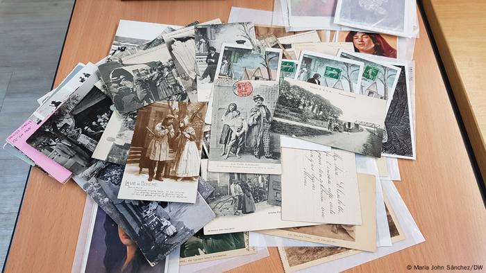 Unsortierter Stapel mit Postkarten, auf denen Fotografien von Sinti und Roma abgedruckt sind