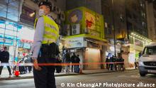 CORRECTS TO SAY 2,000 SMALL ANIMALS, NOT 2,000 HAMSTERS - A police officer stands guard outside a pet store that was closed after some pet hamsters were, authorities said, tested positive for the coronavirus, in Hong Kong, Tuesday, Jan. 18, 2022. Hong Kong authorities said Tuesday that they will kill about 2,000 small animals, including hamsters, after several tested positive for the coronavirus at the pet store where an employee was also infected. (AP Photo/Kin Cheung)