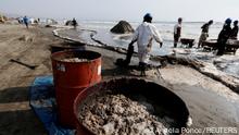 Workers clean an oil spill caused by abnormal waves, triggered by a massive underwater volcanic eruption in Tonga, off the coast of Lima, in Ventanilla, Peru January 19, 2022. REUTERS/Angela Ponce