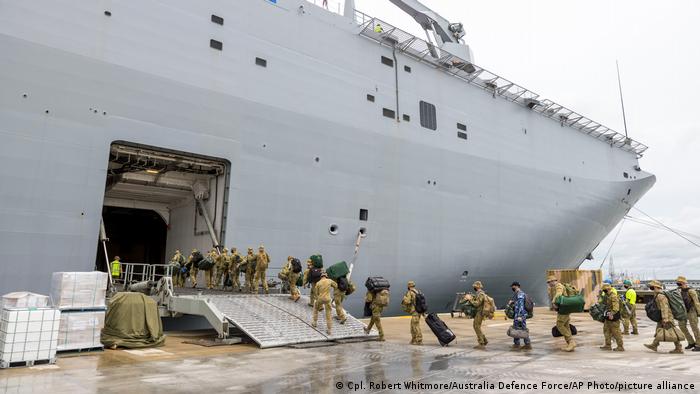 In this photo provided by the Australian Defence Force, soldiers load onto HMAS Adelaide at the Port of Brisbane before departing for Tonga Thursday