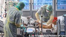 Medical staff assist a patient infected with the Covid-19 coronavirus in the Covid-19 intensive care unit (ICU) of the University hospital (Bergmannsheil Klinikum) in Bochum, western Germany, on December 16, 2021, amid the novel coronavirus COVID-19 pandemic. - The EU health agency ECDC on December 15, 2021 warned that vaccinations alone would not stop the rise of the Omicron variant of the novel coronavirus, and said strong action was urgently needed. (Photo by Ina FASSBENDER / AFP) (Photo by INA FASSBENDER/AFP via Getty Images)