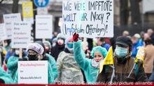 Eine Demonstrantin hält ein Schild mit der Aufschrift Wie viele Impftote wollt ihr noch? (Impfschäden Offenlegen)!. Die Demonstration richtet sich gegen die staatlichen Corona-Regeln. +++ dpa-Bildfunk +++