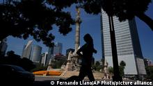 A man jogs past the Angel of Independence monument in Mexico City, Monday, Oct. 18, 2021. Starting Monday, Mexico City lifts some of its COVID-19 restrictions, allowing bars, clubs and indoor events to fill up to 50% capacity, while massive outdoor events can fill to capacity but masks will still be required. (AP Photo/Fernando Llano)