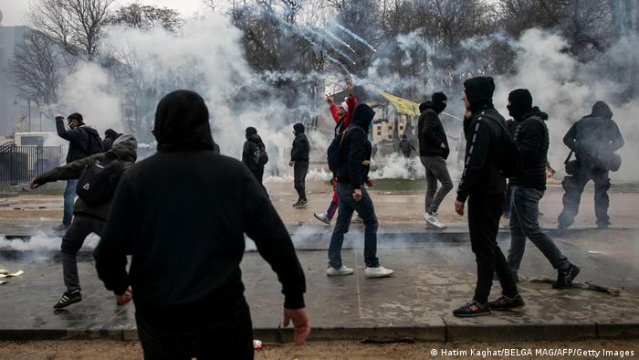 Протестующие в черной одежде в клубах слезоточивого газа в Брюсселе