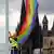 man hoists a rainbow flag with St. Martin's Church in the background