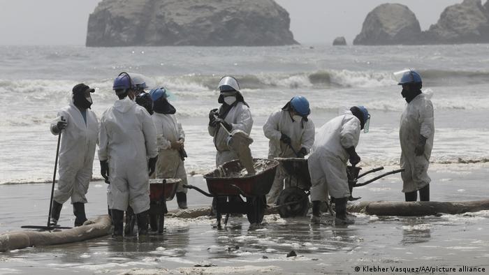 Foto de personal de limpieza en una playa de Perú.