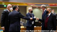 Austrian Foreign Minister Alexander Schallenberg, second left, greets Cypriot Foreign Minister Ioannis Kasoulides, right, during a meeting of EU foreign ministers at the European Council building in Brussels, Monday, Jan. 24, 2022. European Union foreign ministers are aiming Monday to show a fresh display of resolve and unity in support of Ukraine, amid deep uncertainty about whether President Vladimir Putin intends to attack Russia's neighbor or send his troops across the border. (AP Photo/Virginia Mayo)