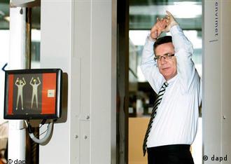 German Interior Minster Thomas de Maizière passes through an airport body scanner