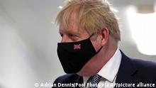 Britain's Prime Minister Boris Johnson wears a face mask, during a visit to Milton Keynes University Hospital in Buckinghamshire, England, Monday, Jan. 24, 2022. (Adrian Dennis/Pool Photo via AP)