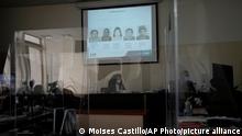 Photos of victims of human rights violations during Guatemala's civil war are projected in court above Judge Yassmin Barrios during the trial of five former civil defense patrolmen in Guatemala City, Tuesday, Jan. 18, 2022. The accused, who fought alongside soldiers as civilians, are accused of sexual assault and human rights violations against dozens of Indigenous women from the Mayan Achi ethnic group during the nation's civil war. (AP Photo/Moises Castillo)