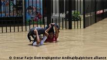 Einwohner der Stadt Piura (Peru) laufen am 28.03.2017 durch eine überschwemmte Straße. In Peru gilt wegen der Überschwemmungen weiter der Notstand. (zu dpa «Peru kämpft weiter gegen Regen und Überschwemmungen» vom 28.03.2017) Foto: Oscar Farje Gomero/Agentur Andina/dpa +++ dpa-Bildfunk +++