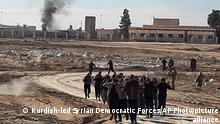 This photo provided by the Kurdish-led Syrian Democratic Forces, shows some Islamic State group fighters, who surrendered after clashing with Kurdish-led Syrian Democratic Forces, at Gweiran Prison, in Hassakeh, northeast Syria, Monday, Jan. 24, 2022. Clashes between U.S.-backed Syrian Kurdish fighters and militants continued for a fourth day Sunday near the prison in northeastern Syria that houses thousands of members of IS, the Kurdish force said. (Kurdish-led Syrian Democratic Forces, via AP)