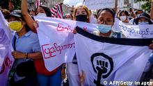 Women carry banners as they march during a demonstration against the military coup in Yangon on July 14, 2021. (Photo by STR / AFP) (Photo by STR/AFP via Getty Images)