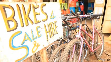A sign that reads: Bikes 4 Sale & Hire, standing next to a several mountain bikes