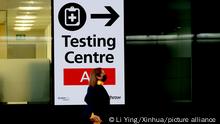 (211201) -- LONDON, Dec. 1, 2021 (Xinhua) -- A passenger walks past a placard indicating the testing center in Heathrow Airport in London, Britain, Nov. 30, 2021. British Prime Minister Boris Johnson said Saturday all travellers entering Britain must take a PCR test by the end of the second day after their arrival, and must self-isolate until they receive a negative test result. Passengers arriving in Britain from countries in Britain's travel red list, including South Africa, from 0400 GMT on Nov. 28 will be required to book and pay for a government-approved hotel to quarantine for 10 days. Omicron, a new COVID-19 variant, has been detected in a growing number of countries and regions worldwide, prompting governments to tighten their restrictions and impose new travel bans. (Xinhua/Li Ying)