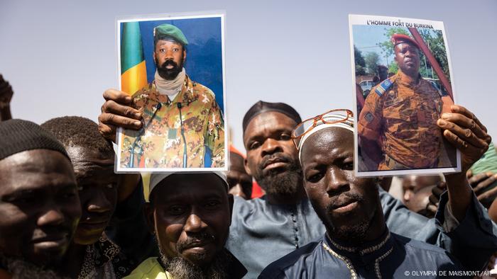 Burkinabe men holding up pictures