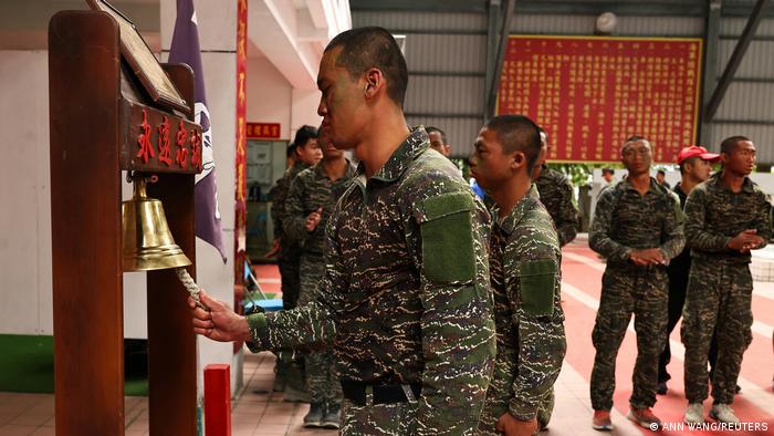 A trainee rings a bell, marking the end of the training program