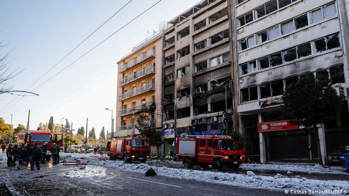 Firefighter vehicles are seen outside a building after a blast in Athens